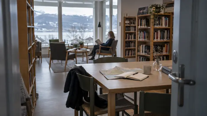 Rolig arbeidsplass med notater og utsikt til et norsk lokalmiljø